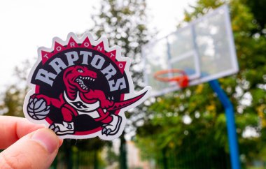 15 Eylül 2021 'de Toronto, Kanada' da bir adam Toronto Raptors basketbol kulübünün amblemini elinde tutuyor..