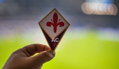 12 Eylül 2021, Floransa, İtalya. Futbol kulübü ACF Fiorentina 'nın amblemi modern stadyumun arka planına karşıdır..