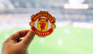 30 Ağustos 2021, Manchester, İngiltere. Manchester United F.C. Modern bir stadyumun arka planına karşı futbol kulübü amblemi..
