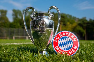 30 Ağustos 2021, Münih, Almanya. FC Bayern Münih futbol amblemi ve UEFA Şampiyonlar Ligi Kupası stadyumun yeşil sahasında.