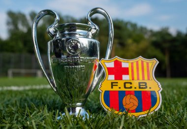 30 Ağustos 2021, Barselona, İspanya. Modern bir stadyumun arka planında FC Barcelona futbol kulübü ve UEFA Şampiyonlar Ligi Kupası amblemi yer almaktadır..