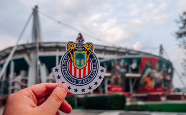 30 Ağustos 2021, Guadalajara, Meksika. Futbol kulübü C.D. 'nin amblemi. Guadalajara modern bir stadyumun arka planına karşı..