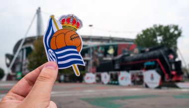 30 Ağustos 2021, San Sebastian, İspanya. Futbol kulübü Real Sociedad 'ın amblemi modern bir stadyumun arka planına karşı..