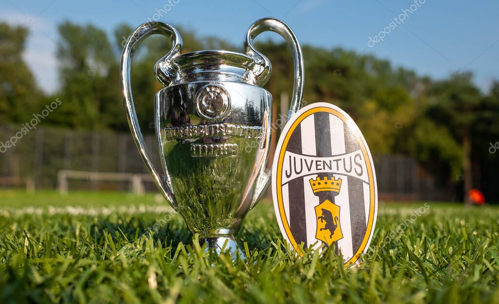 August 30, 2021, Turin, Italy. The Juventus football club emblem and the UEFA Champions League Cup on the green turf of the stadium.