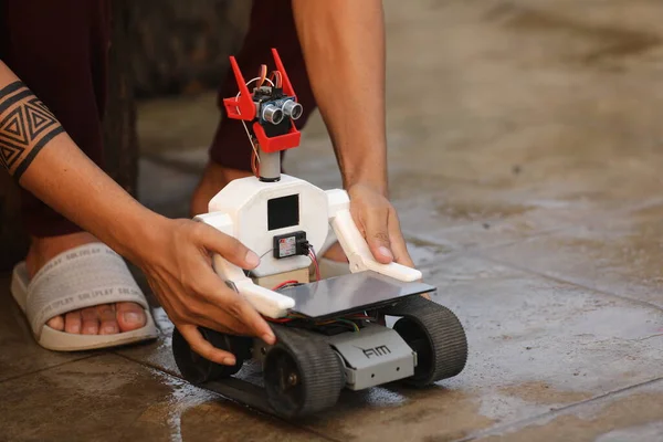 Hands Holding Remote Controlling Robot