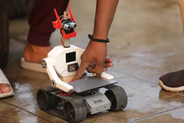 Hands Holding Remote Controlling Robot