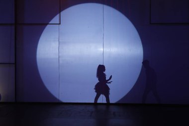 Dansçılar sahnede gölgeler.