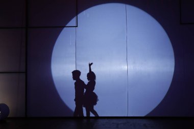 Dansçılar sahnede gölgeler.