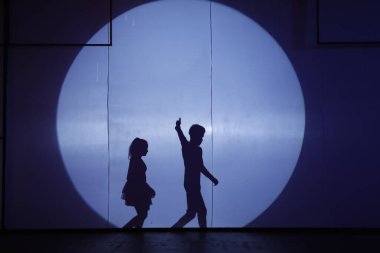 Dansçılar sahnede gölgeler.