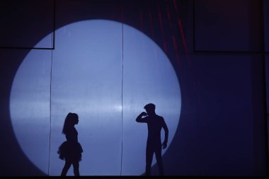 Dansçılar sahnede gölgeler.