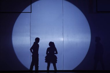 Dansçılar sahnede gölgeler.