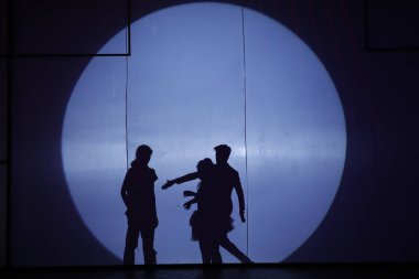 Dansçılar sahnede gölgeler.