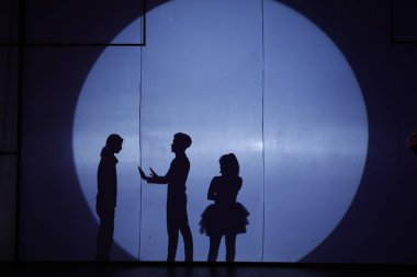 Dansçılar sahnede gölgeler.