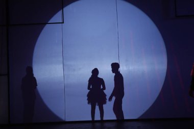 Dansçılar sahnede gölgeler.