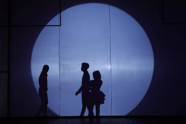 Dansçılar sahnede gölgeler.