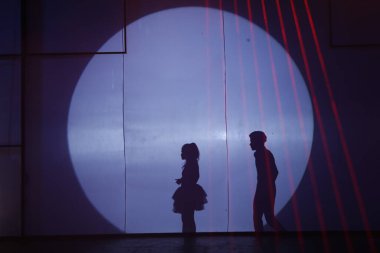 Dansçılar sahnede gölgeler.