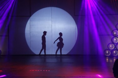 Dansçılar sahnede gölgeler.