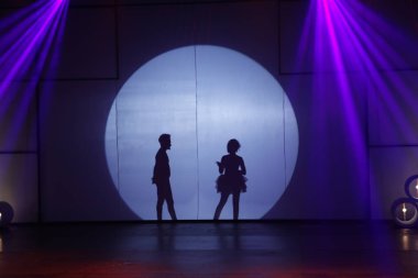 Dansçılar sahnede gölgeler.