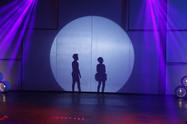 Dansçılar sahnede gölgeler.