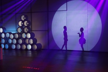 Dansçılar sahnede gölgeler.