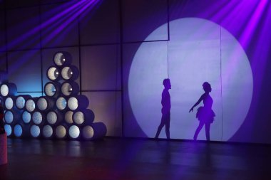 Dansçılar sahnede gölgeler.