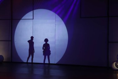 Dansçılar sahnede gölgeler.