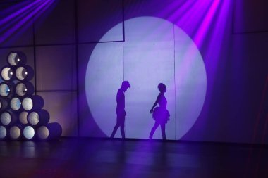 Dansçılar sahnede gölgeler.