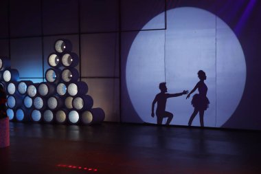 Dansçılar sahnede gölgeler.