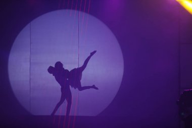 Dansçılar sahnede gölgeler.