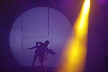 Dansçılar sahnede gölgeler.