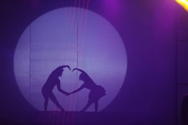 Dansçılar sahnede gölgeler.