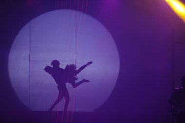 Dansçılar sahnede gölgeler.