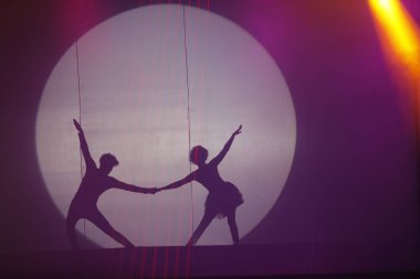 Dansçılar sahnede gölgeler.