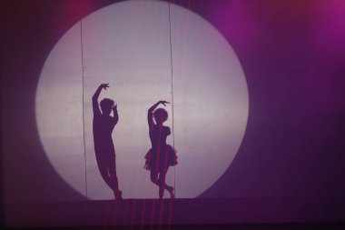 Dansçılar sahnede gölgeler.