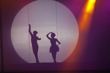 Dansçılar sahnede gölgeler.