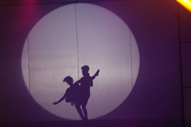 Dansçılar sahnede gölgeler.