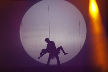 Dansçılar sahnede gölgeler.