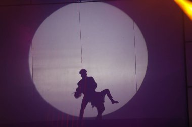 Dansçılar sahnede gölgeler.