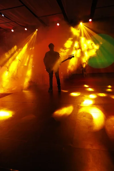 ステージ上でギターを持つ音楽家のシルエット — ストック写真