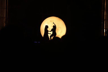 Dansçılar sahnede Ay ışığının gölgesinde