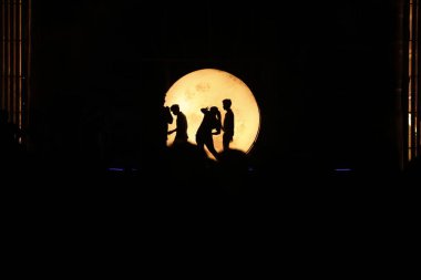 Dansçılar sahnede Ay ışığının gölgesinde