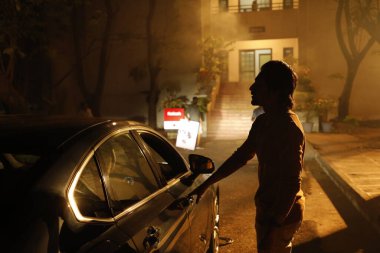 Araba kapısındaki adamın silueti.