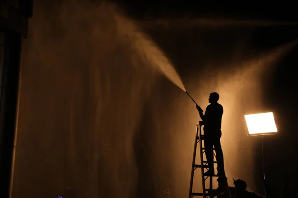 Silhouette Of Firefighter with Fire Hose Nozzle