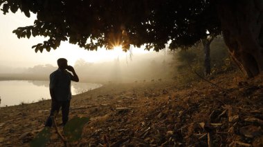 Telefonu olan bir adam silueti.