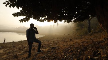 Telefonu olan bir adam silueti.