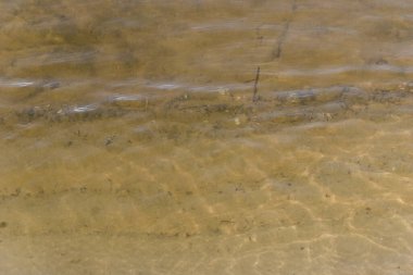 Suyun yüzeyindeki parıltı kırılır ve gölün, nehrin ya da denizin dibinde güzel bir desen oluşturur.