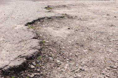 Asfalt yolda taşlı büyük çukurlar. Büyük delikli çok kötü asfalt yol..