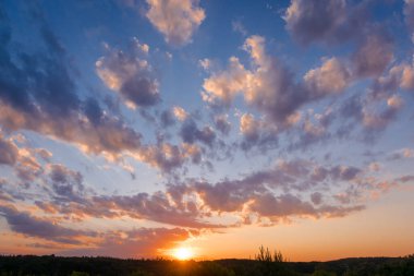 Bulutların üzerinde dramatik bir ışıkla gün batımı. Çok renkli bulutlu gün batımı gökyüzü. Dramatik alacakaranlık arkaplanı