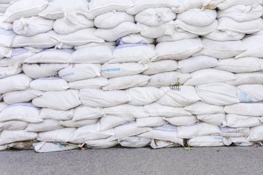 Kum torbalarından yapılmış bir barikat duvarı. Savunma konsepti, Bags savaş sırasında savunma yapısını güçlendirmek için. Savaş zamanında korunma. Arkaplan veya doku olarak beyaz kum torbaları.