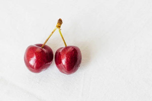 Two Juicy Berries Red Cherry White Fabric Background Couple Red — стоковое фото